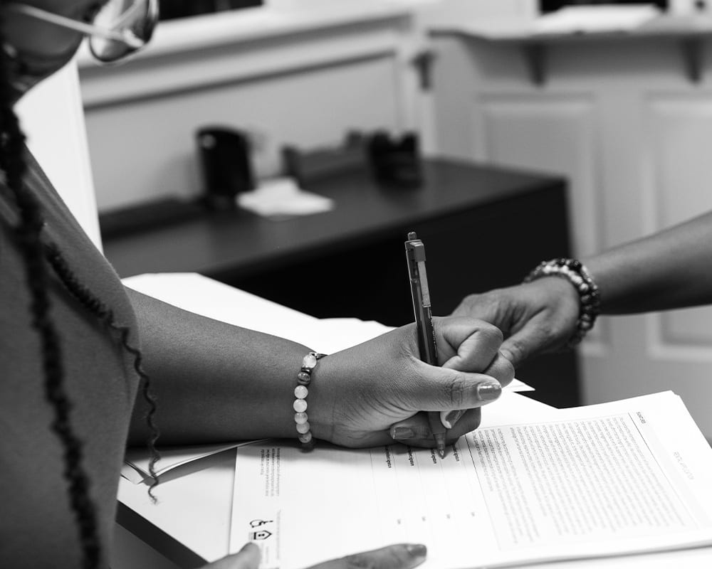 Two people sign legal papers