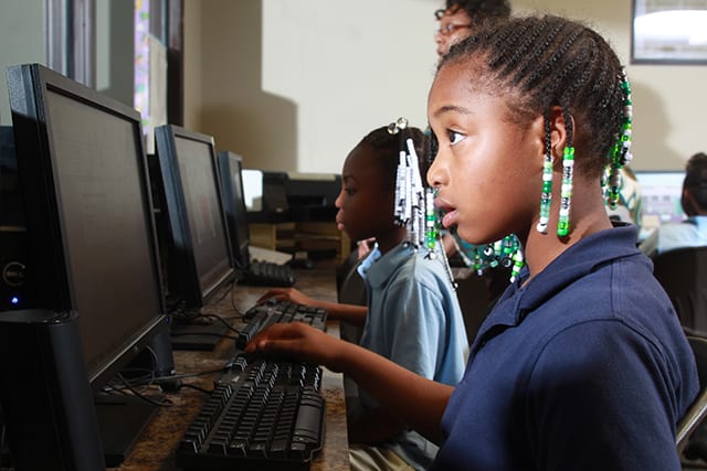 Two children work on the computer