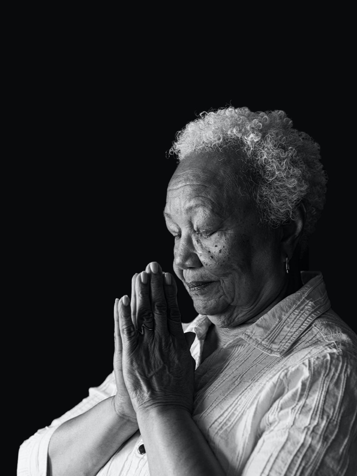 An elderly woman prays